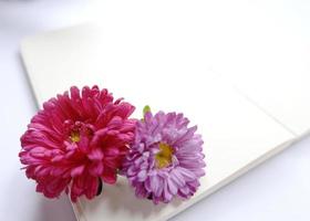 blanco notebook met roze en paarse bloem foto