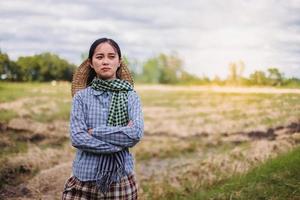 jong mooi boer vrouw staand Aan bouwland en inspecteren agrarisch gewassen foto