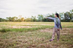 jong mooi boer vrouw staand Aan bouwland en inspecteren agrarisch gewassen foto