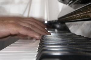 handen spelen piano terwijl in beweging foto