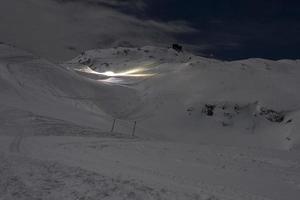 sneeuwscooter Aan ski rennen Bij nacht foto
