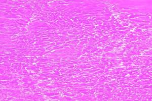 onscherp wazig transparant Purper gekleurde Doorzichtig kalmte water oppervlakte structuur met spatten en bubbels. modieus abstract natuur achtergrond. water golven in zonlicht met kopiëren ruimte. roze water schijnend foto