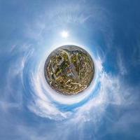 klein planeet in lucht met wolken met uitzicht oud dorp, stedelijk ontwikkeling, historisch gebouwen en kruispunt. transformatie van bolvormig 360 panorama in abstract antenne visie. foto