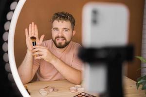 Mens maken omhoog vlogger opname uitzending over schoonheidsmiddelen en tutorials voor bedenken artiest foto