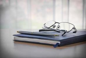 bril en pen op een boek foto