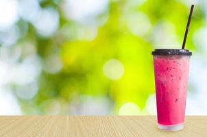 ijs thee, bevroren roze melk thee Aan groen natuur achtergrond ,zomer drankjes met ijs foto