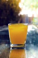 bevroren oranje sap glas Aan bokeh achtergrond foto