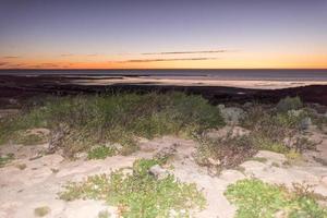 zonsondergang in koraal baai kristal water zanderig strand paradijs foto