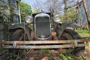 oud verlaten verroest auto in een veld- foto