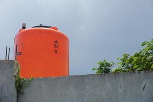 groot oranje water reservoir Aan de dak van de huis. foto