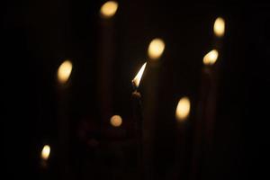 kaarsen brandwond in donker. kaars lichten. vlammen Aan zwart achtergrond. foto