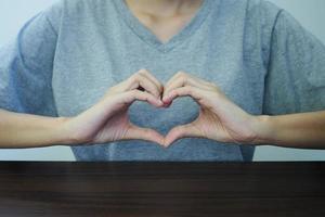 detailopname visie van hand- schot van mooi jong vrouw maken hart gebaar. concept van liefde en geluk. foto