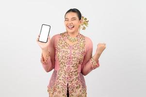 jong mooi vrouw jurk omhoog in lokaal cultuur in zuidelijk regio houding met smartphone foto