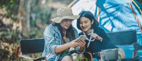 Aziatisch mooi vrouw en vriend gebruik smartphone selfie Aan camping foto