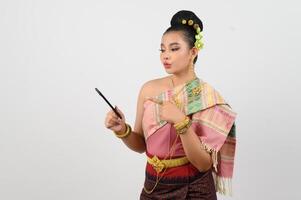 jong mooi vrouw jurk omhoog in Thais noordelijk regio houding met smartphone foto