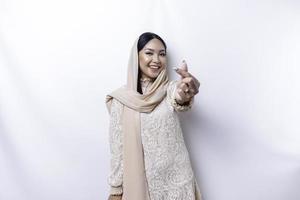 een gelukkig jong Aziatisch vrouw vervelend hijab voelt romantisch vormen hart gebaar drukt uit inschrijving gevoelens foto