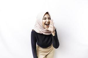 jong mooi Aziatisch moslim vrouw vervelend een hijab geschreeuw en schreeuwen luid met een hand- Aan haar mond. communicatie concept. foto