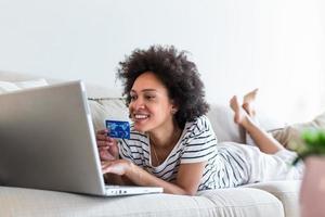 vrouw klant uitgeven buying Aan internetten, levensstijl. gelukkig vrouw boodschappen doen online met laptop Bij huis. vrouw gebruik makend van laptop computer boodschappen doen Aan lijn, gebruik makend van credit kaart spelen online, glimlachen binnenshuis foto