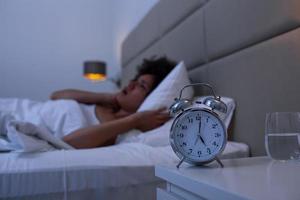 vrouw met slapeloosheid aan het liegen in bed met Open ogen. meisje in bed lijden slapeloosheid en slaap wanorde denken over zijn probleem Bij nacht foto