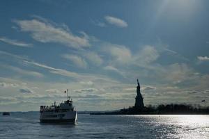 nieuw york standbeeld van vrijheid zwart silhouet met veerboot schip boot foto