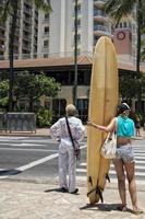 surfer meisje kruispunt de straat in waikiki foto