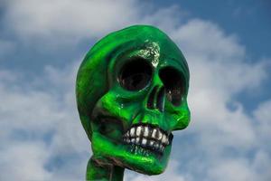 een groen papier schedel Aan bewolkt lucht achtergrond foto
