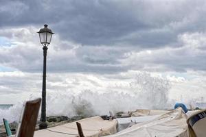 zee in storm Aan rotsen van Italiaans dorp foto