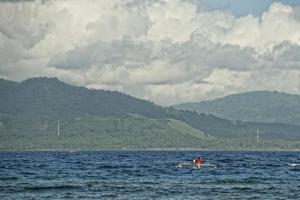 vulkaan achter Indonesisch visser boot in tropisch paradijs foto