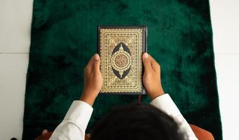 Mens Holding koran boek in top hoek foto