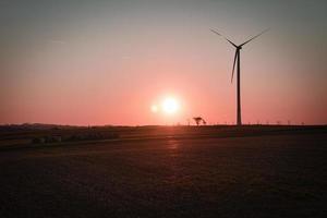 aan land wind turbine Aan een weide Bij zonsondergang. hernieuwbaar energie. schoon elektriciteit foto