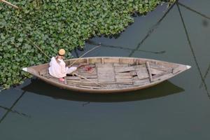 een Mens met visvangst boot en vangst vis door hok foto