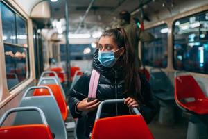 jong vrouw met masker op reis in de openbaar vervoer. foto