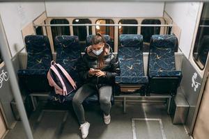 jong vrouw met masker op reis in de openbaar vervoer. foto