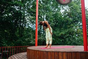 een jong vrouw in aan het doen yoga in de werf foto