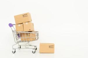 kartonnen dozen in een trolley op een witte achtergrond. online winkelen of e-commerce concept en bezorgserviceconcept met kopie ruimte voor uw ontwerp foto