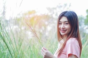 Aziatische vrouw permanent en lachend op de natuur achtergrond foto