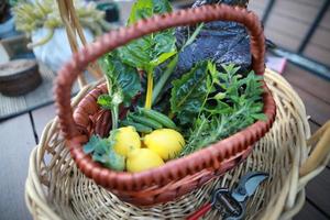 oogstmand met citroenen, groenten, erwten en kruiden foto