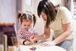 moeder en dochter decoreren kunst met schitteren decor. foto