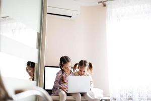 twee meisjes zussen aan het kijken Aan laptop. technologie en huis concept. foto