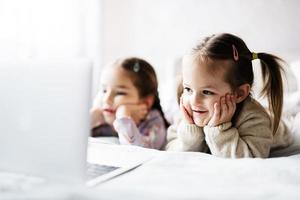 twee meisjes zussen aan het kijken Aan laptop. technologie en huis concept. foto