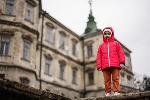 portret van baby meisje in roze met een kap jasje tegen pidhirtsi kasteel, lviv regio, Oekraïne. foto