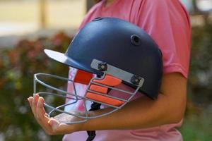krekel speler houdende krekel helm Aan arm buigen uw armen loodrecht naar uw lichaam.zacht en selectief focus. foto