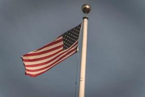 Amerikaans vlag golvend in de wind, Bij de Amerikaans begraafplaats Bij magraten in de nederland. foto