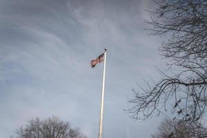 Amerikaans vlag golvend in de wind, Bij de Amerikaans begraafplaats Bij magraten in de nederland. foto