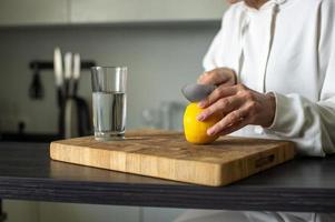 bereiden vitamine water besnoeiing sappig geel citroen met een mes foto