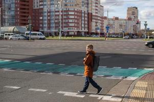 een leerling kruisen de weg Bij een voetganger kruispunt foto