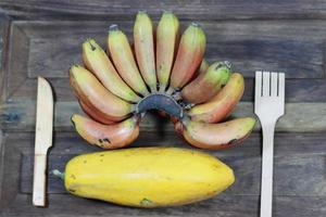 groot banaan fruit en een groot papaja Aan houten achtergrond foto