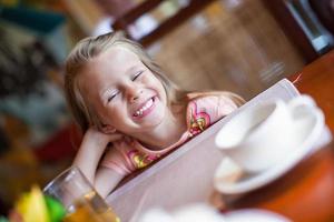 klein meisje ontbijt eten foto