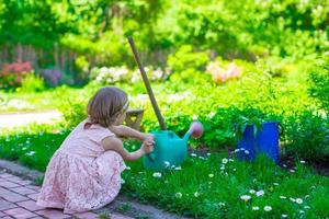 weinig meisje met bloemen in de tuin foto