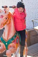 weinig meisje Aan een carrousel foto